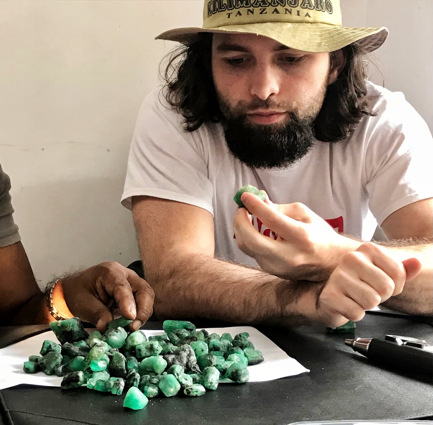 Sorting green rough gemstones at the buying table