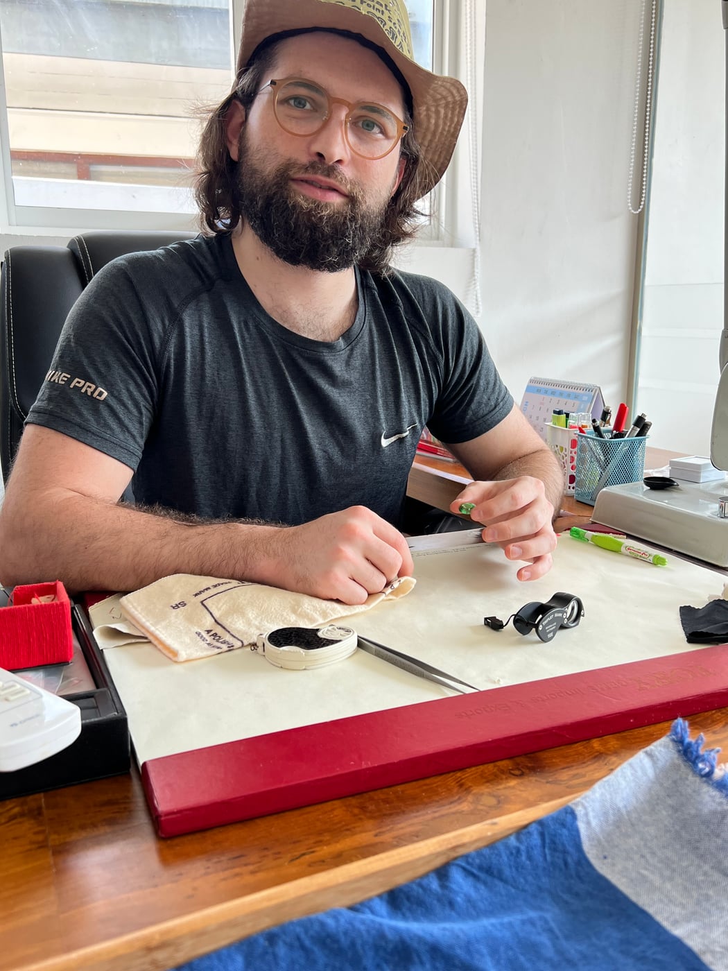 At the Bangkok desk with parcel papers, loupe and tweezers