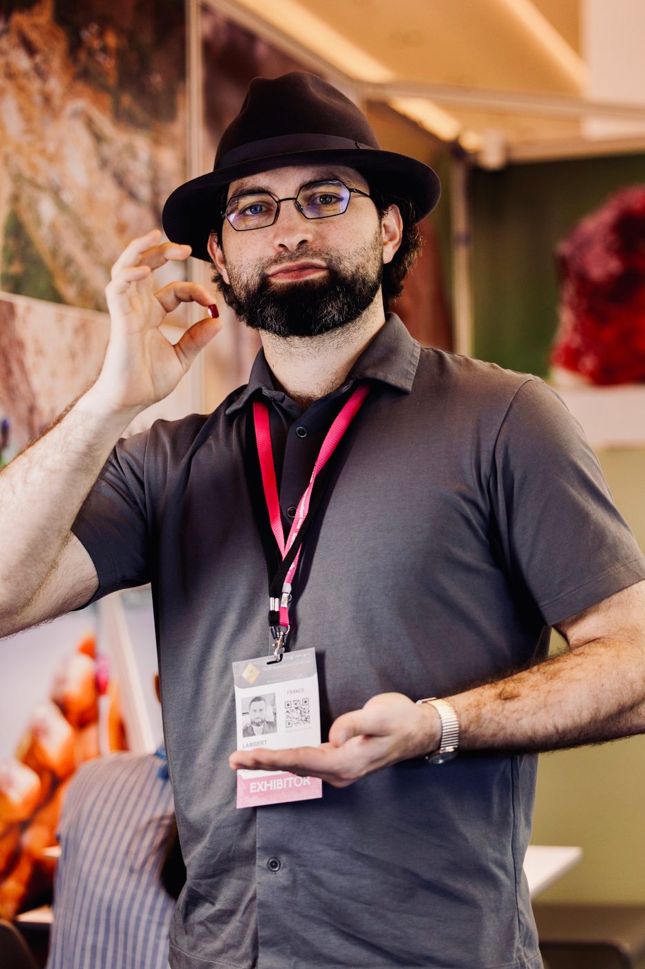 Lambert Vissot holding a red gemstone up between his fingers