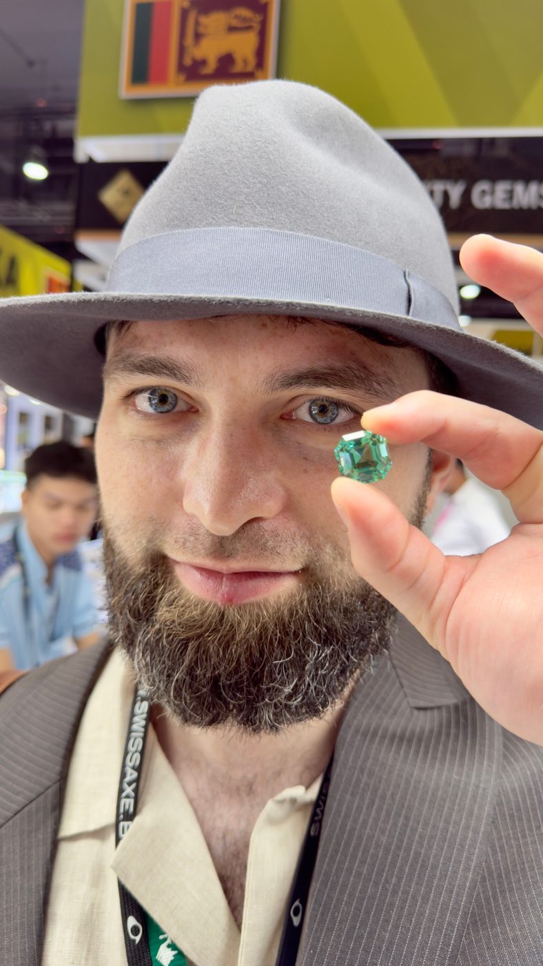 Showing a green gemstone at a gem fair
