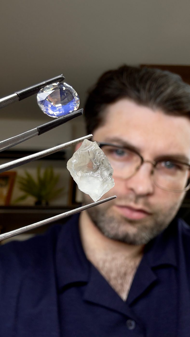 A cut blue stone and a rough crystal held in two tweezers